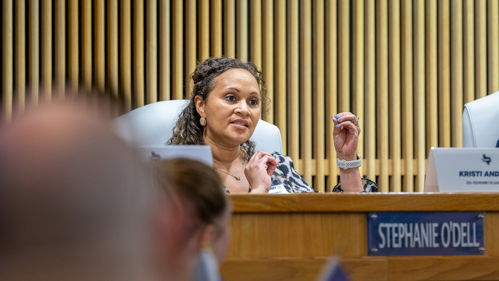 Kristi Andrews speaking and gesturing during panel