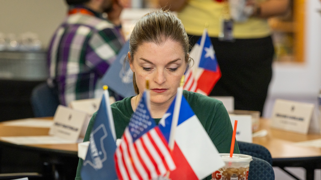 teacher looking down reading at table