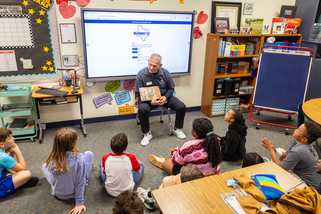 Board vice president Harvey Oaxaca reading in front of class at Minshew Elementary