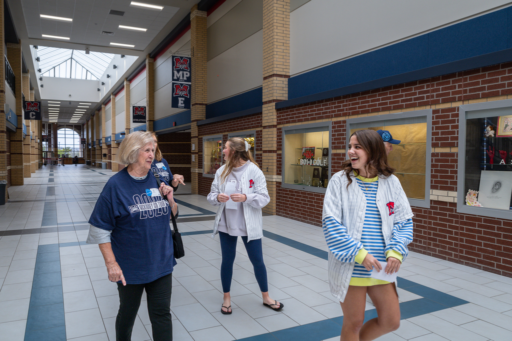 female PALS students leading group down hall while laughing with guests