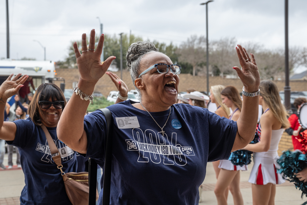 Woman on tour arriving at Boyd raising hands and happily shouting as she walks in