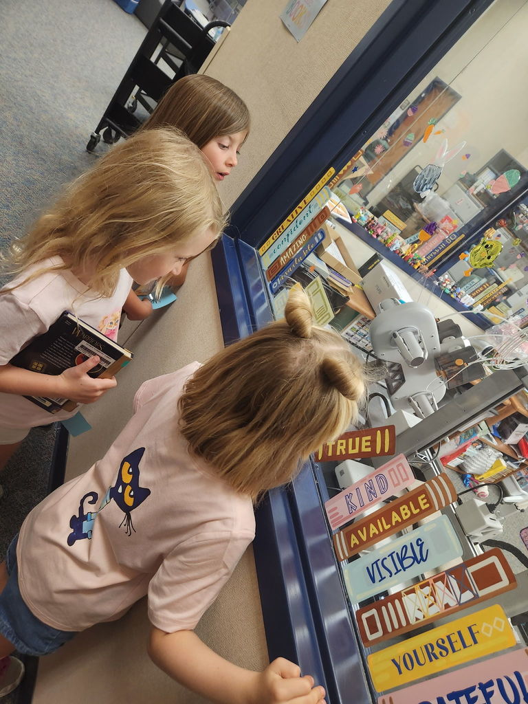 Students watching the 3D printer in the library.