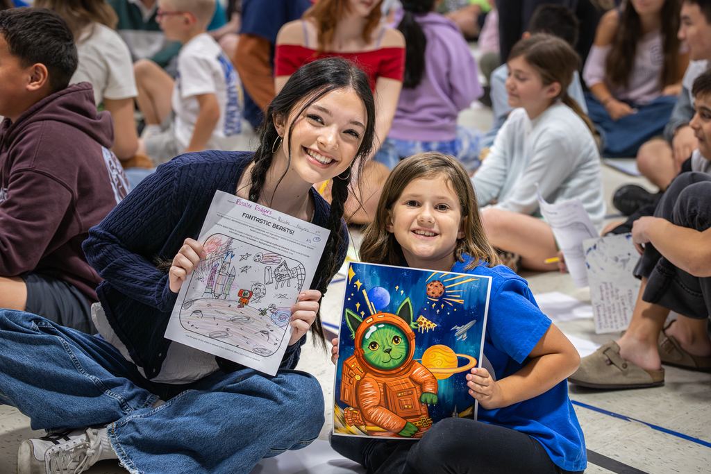 female high school student and 3rd grader smiling and holding up each of their versions of the project