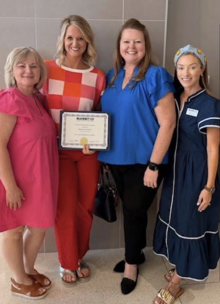 Tracy Meador, Madi Bennett, Dawn Jones and Ashely Garcia standing together with an award