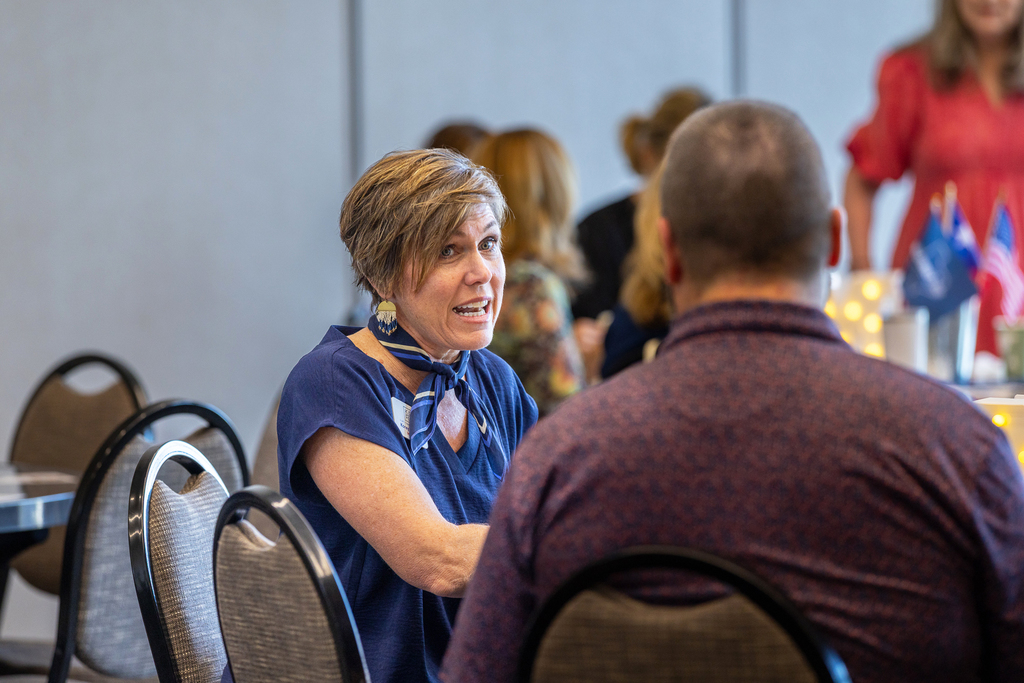 woman at table speaking with a man