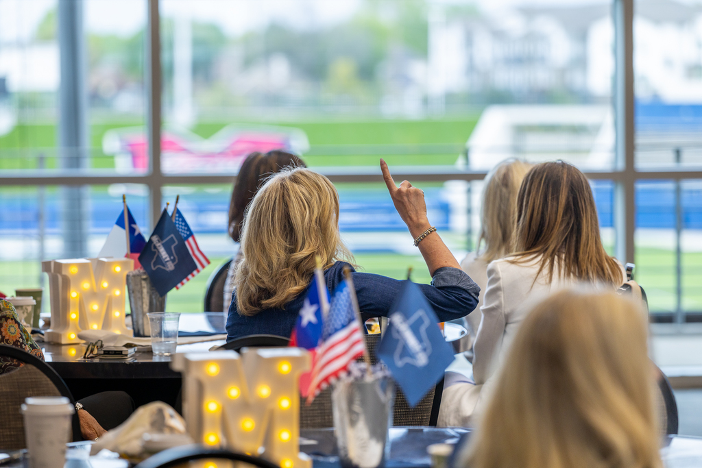 woman raising hand to ask a question