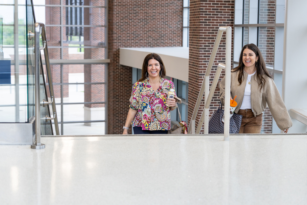 two women coming up the stairs arriving at the event