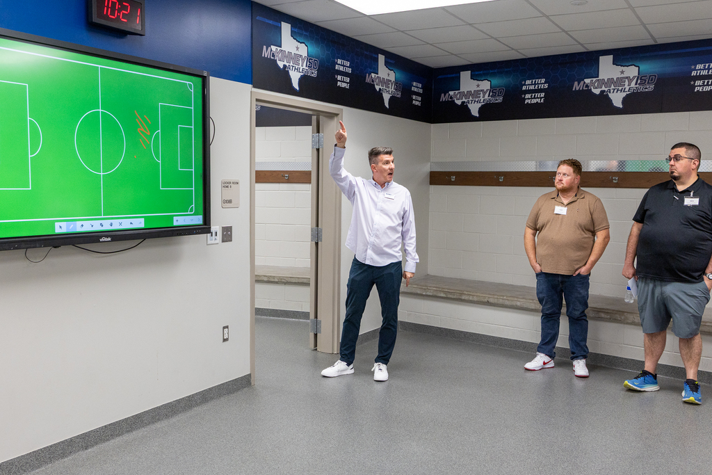 Colby Peek speaking to group in locker room during tour
