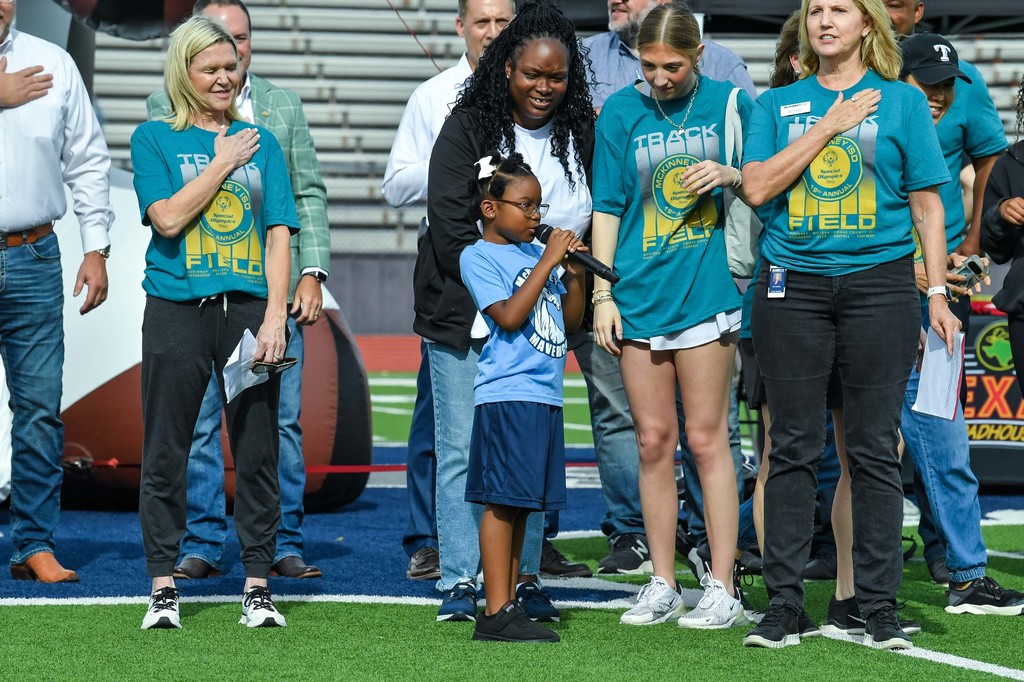 young girl with microphone singing the national anthem