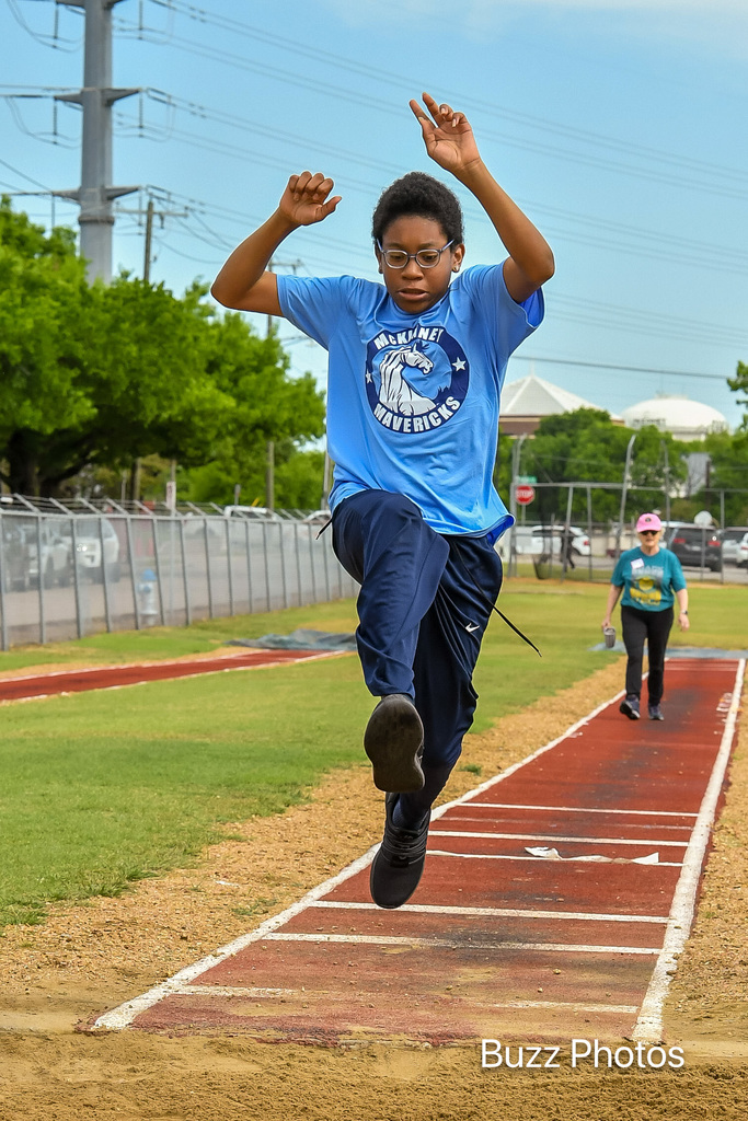 male athlete leaping toward long jump sand