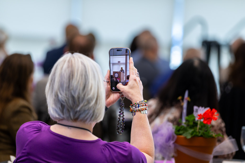 woman holding up phone to take a photo