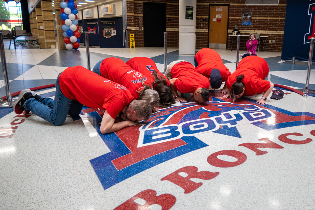 current staff members participate in the kiss the bronco ceremony