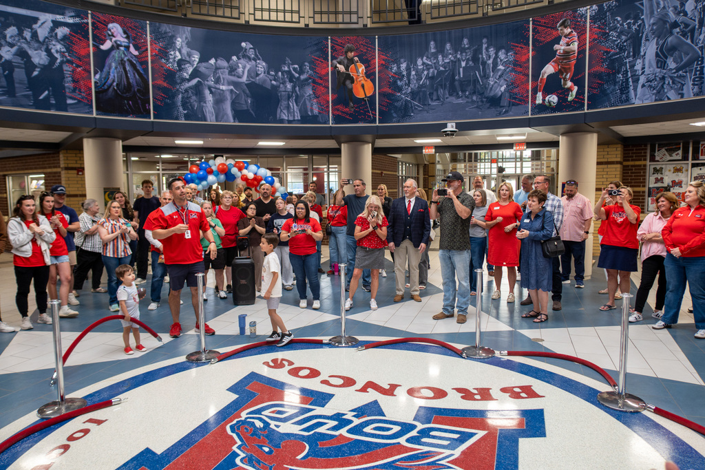staff members and alumni gather before the kiss the bronco ceremony