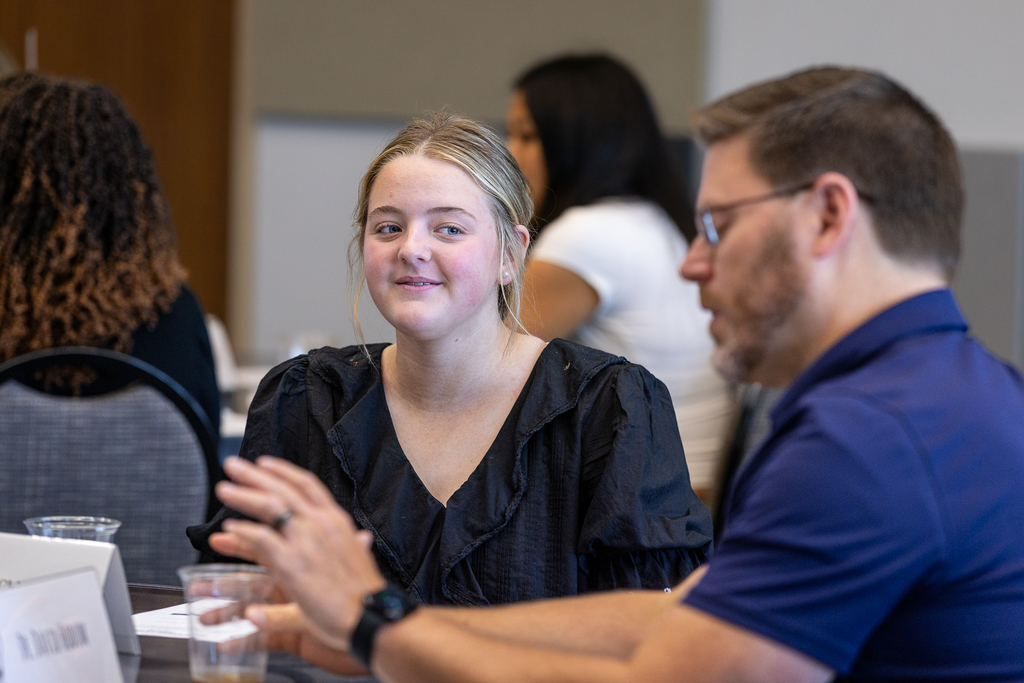 girl smiling during discussion at table
