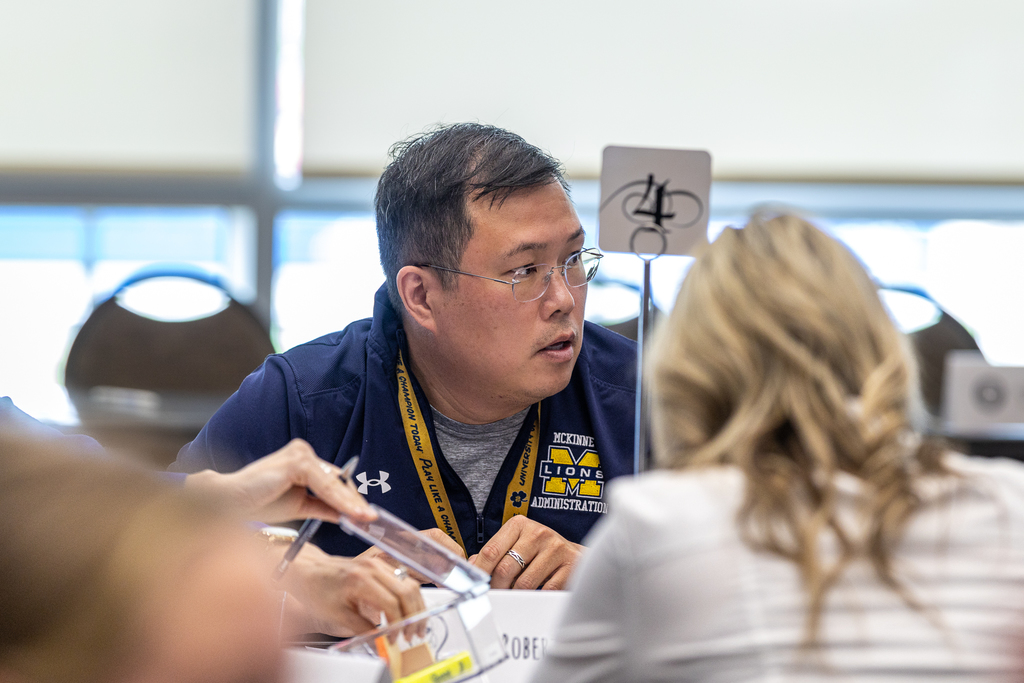 man at table talking with group