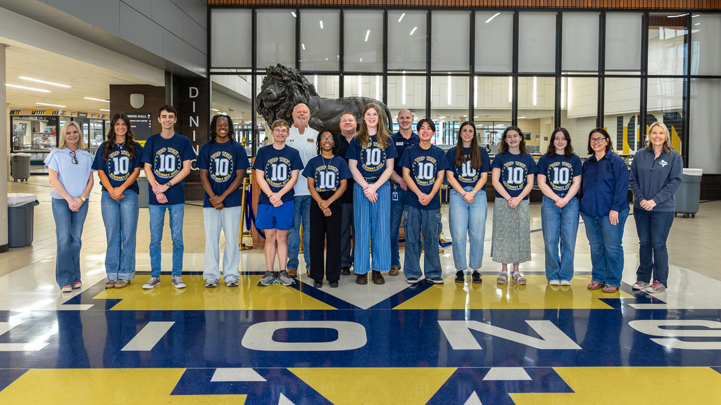 photo with top 10 in a line in front of lion statue with MISD officials