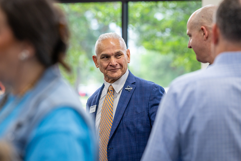 Board member Harvey Oaxaca talking with district leaders before the program