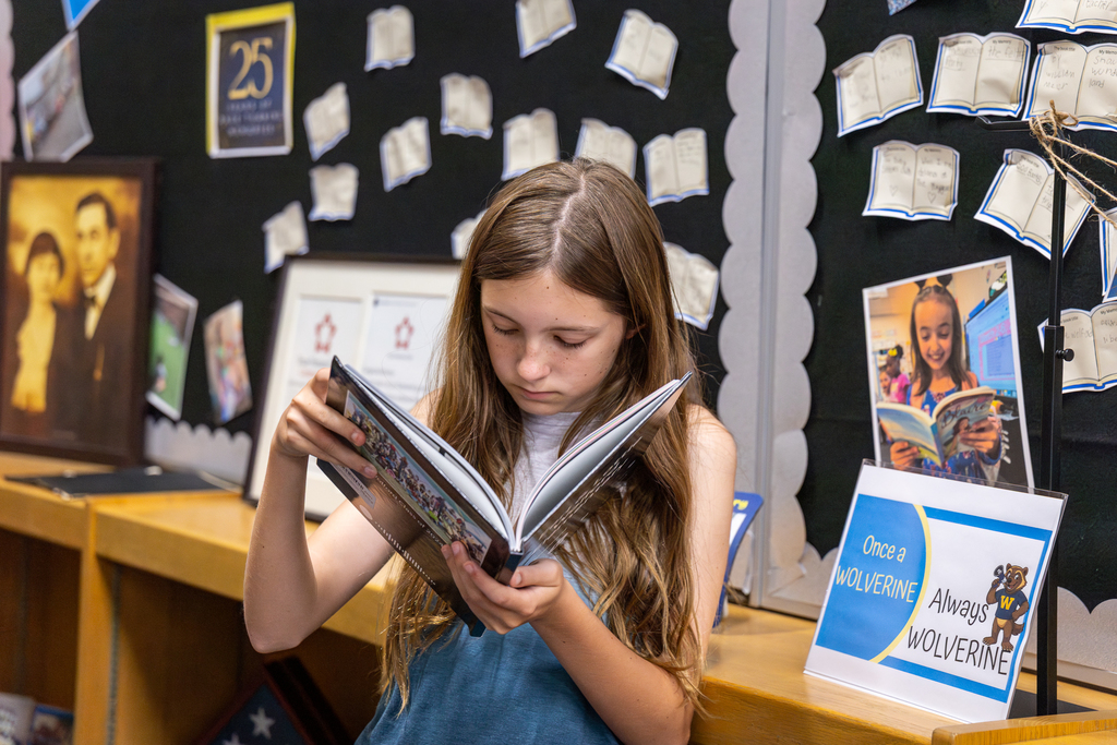 a student at wolford looks through a yearbook 