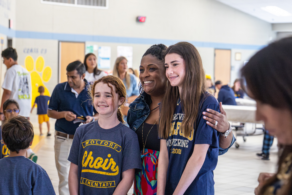 a staff member poses for a photo with two wolford students 
