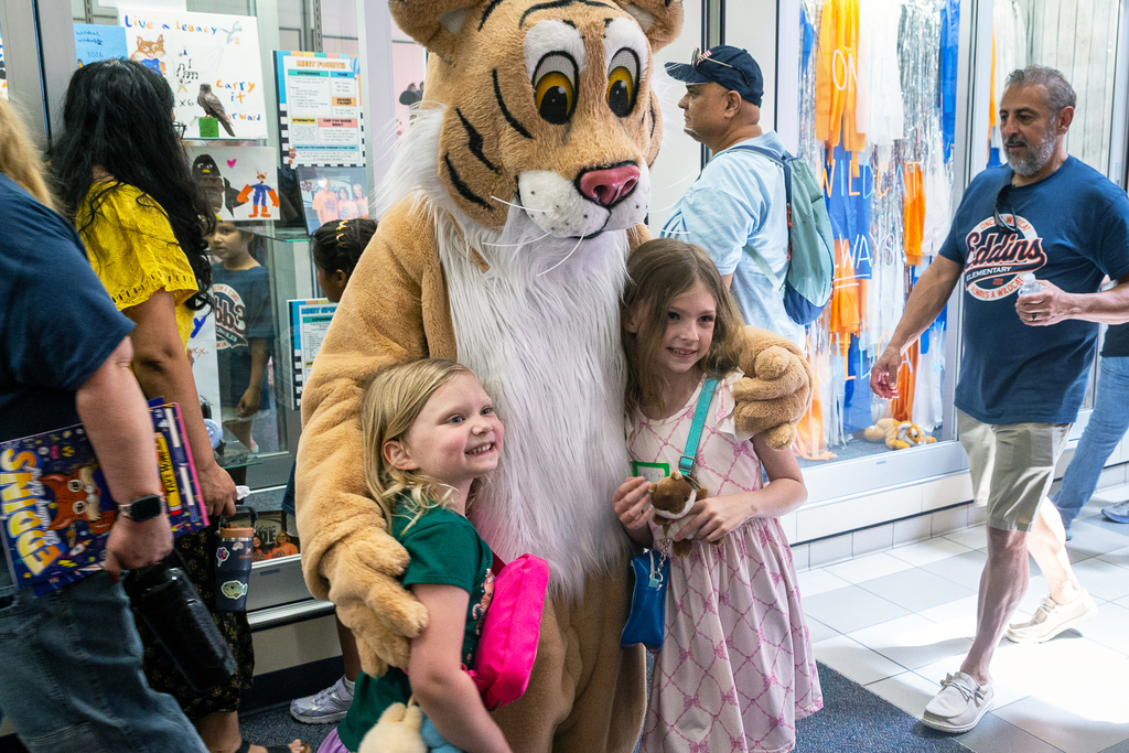 two students post with the eddins mascot for a photo