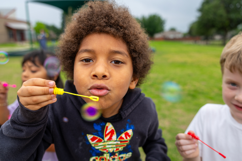 Boyd blowing bubble toward camera