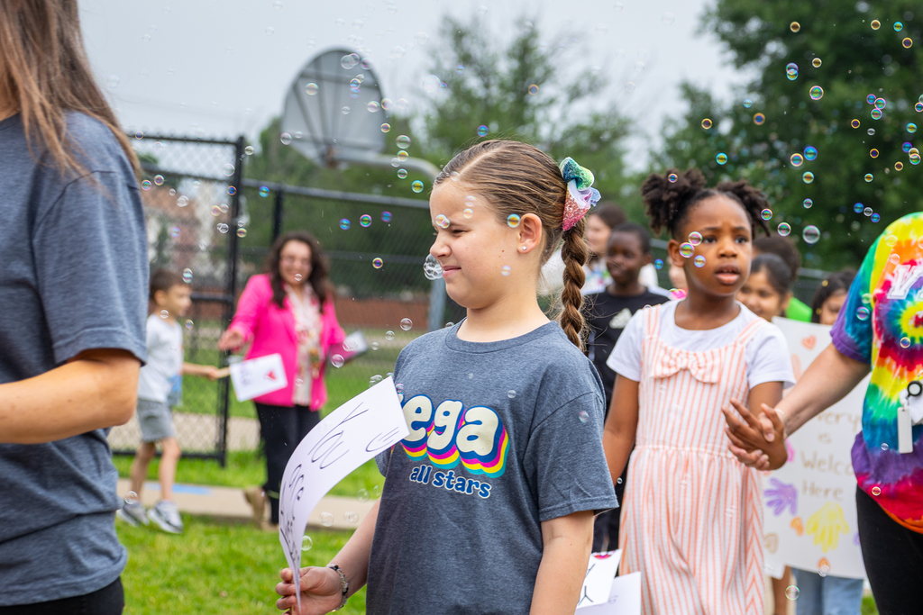 girl in parade closing her eyes as bubbles hit her in the face