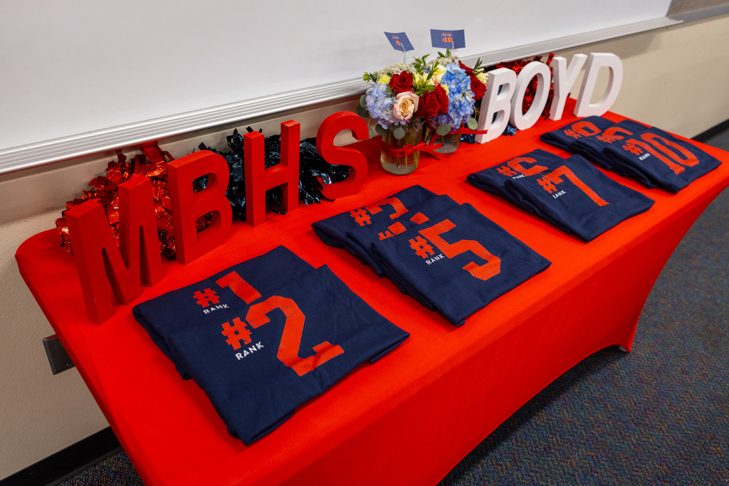 table with MBHS decorations and shirts folded and laid in a row