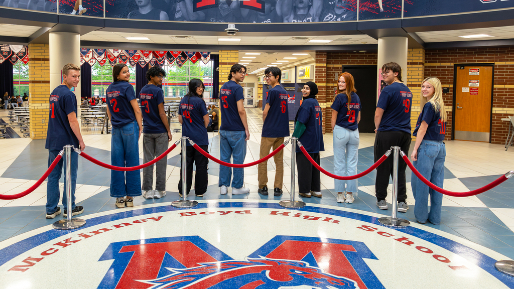 Photo of students in a row looking over shoulder with rank number visible on back of shirt