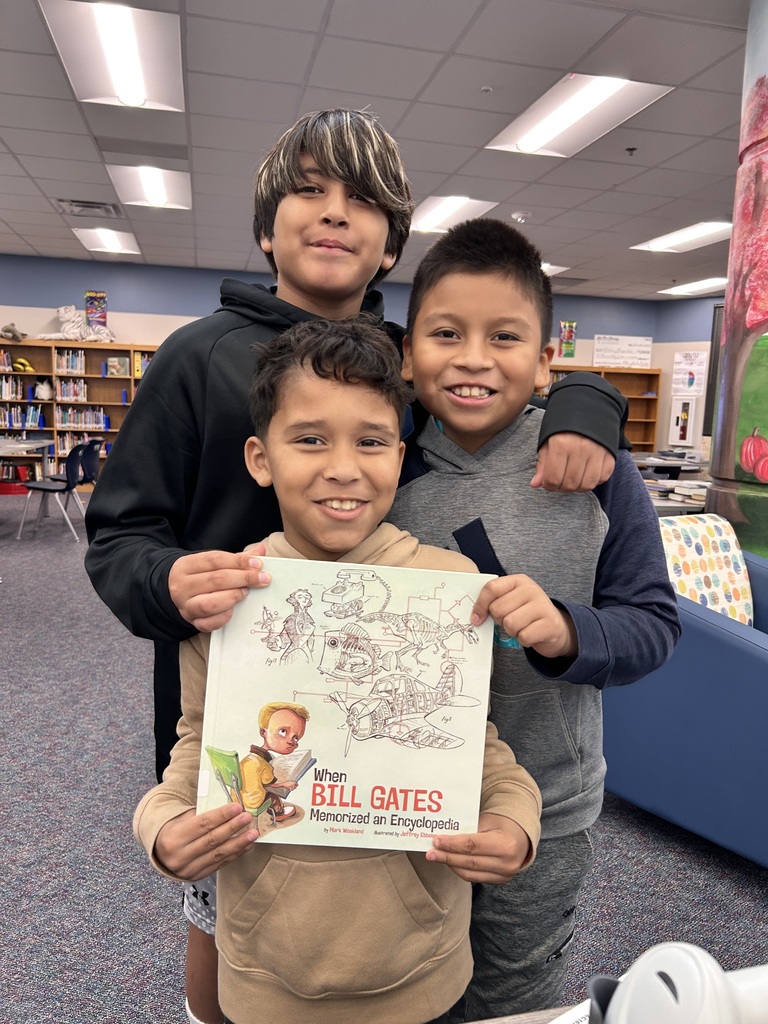 Third graders excited to check out a new biography to use for their research.