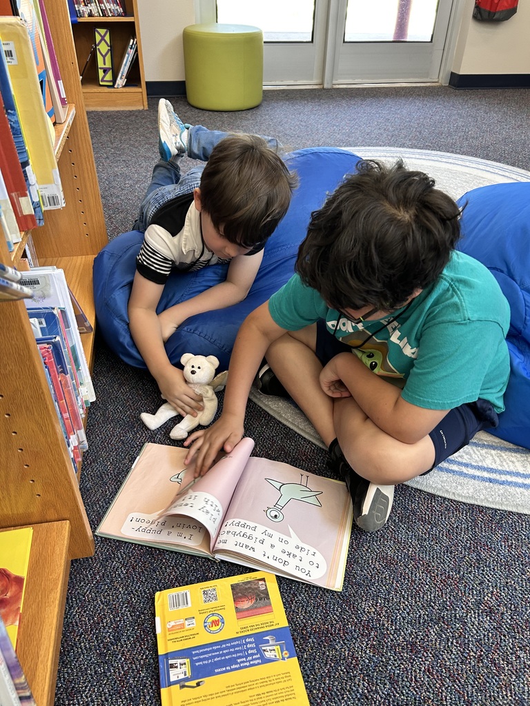 Students reading together on the bean bag chairs and rug.