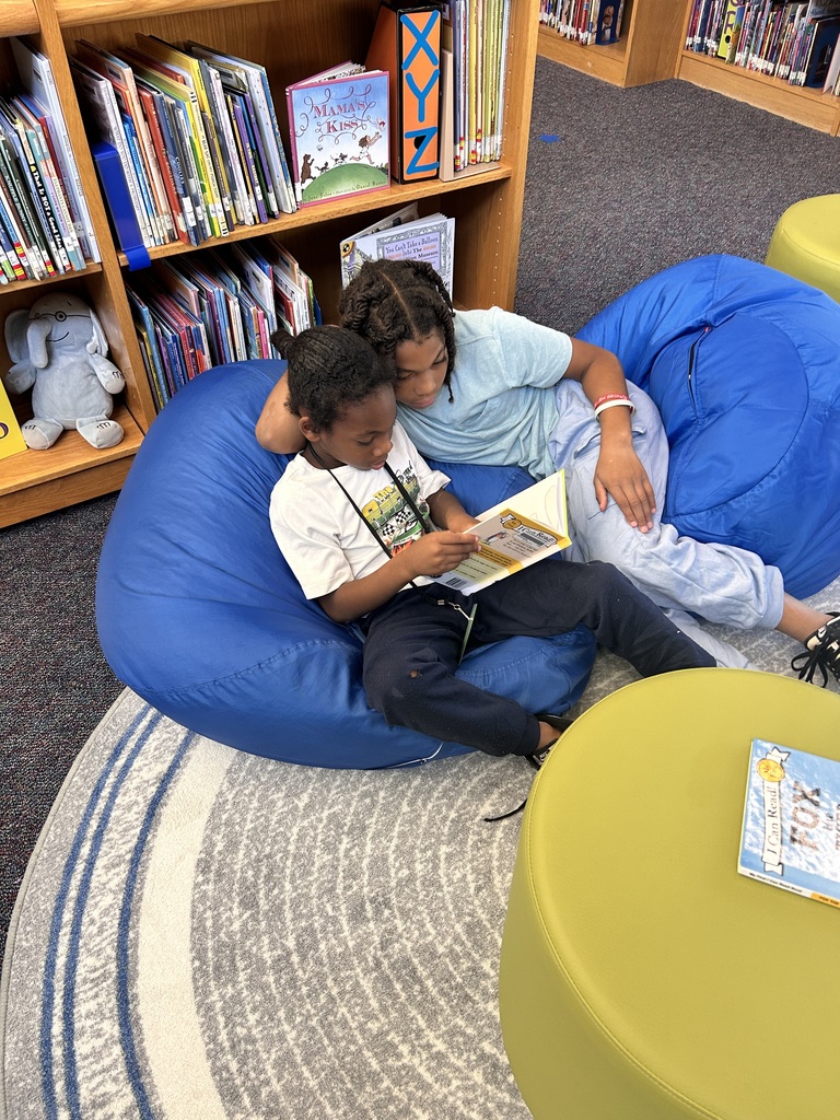 Students reading together on the bean bag chairs and rug.