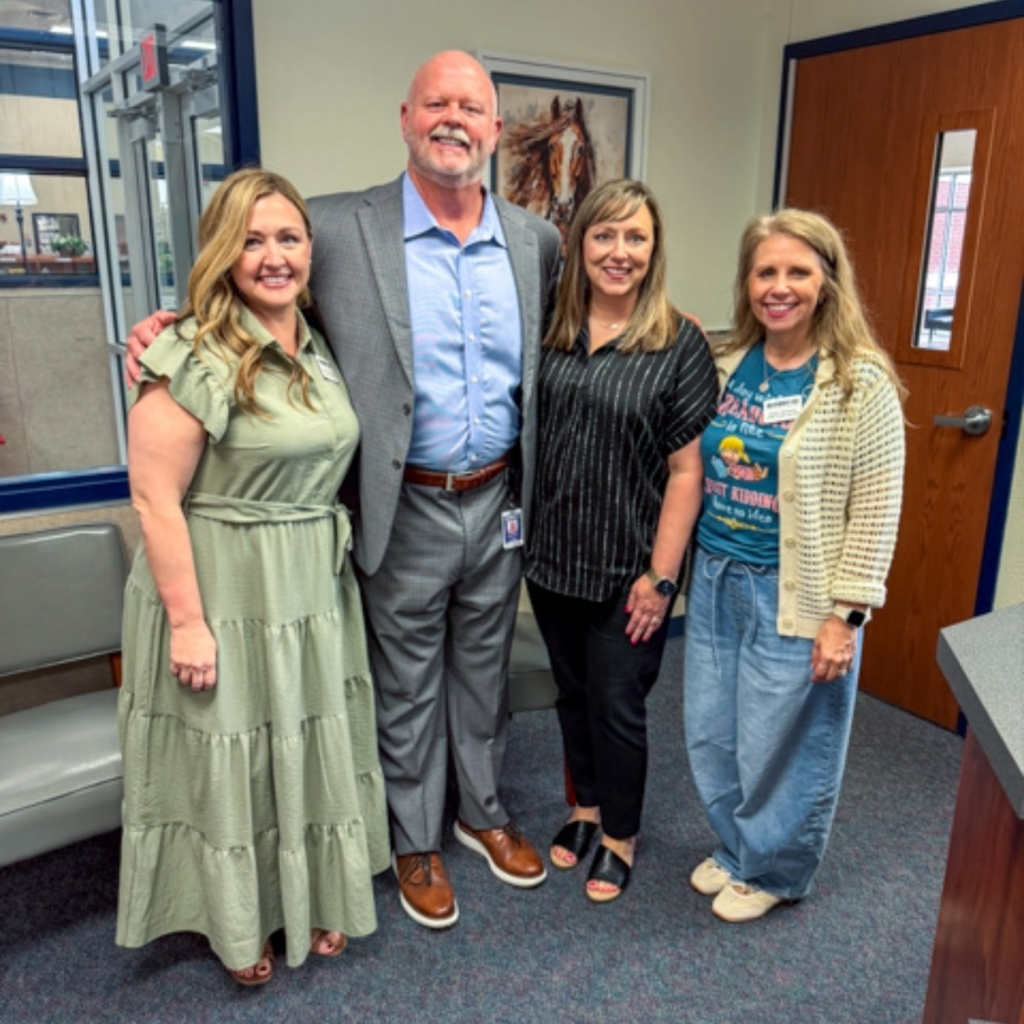 superintendent shawn pratt takes a photo with a teachers at minshew elementary
