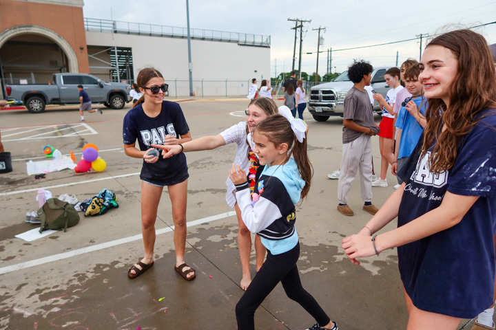 a student throws a water baloon 