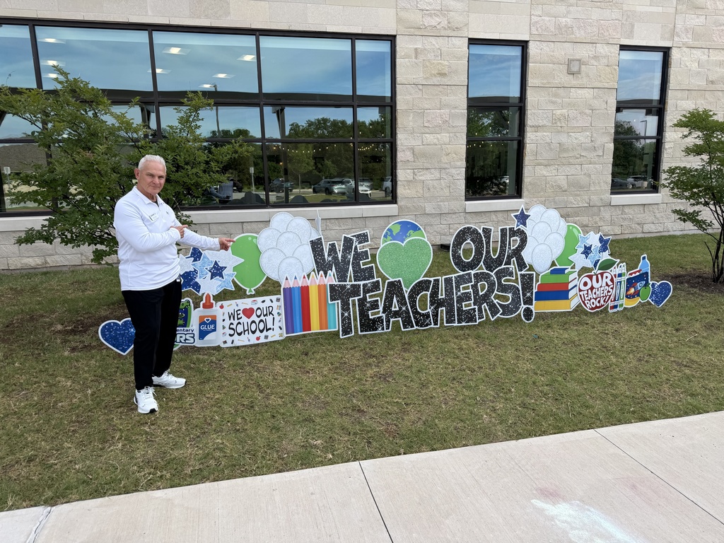 harvey oaxaca takes a photo with the we love our teachers sign
