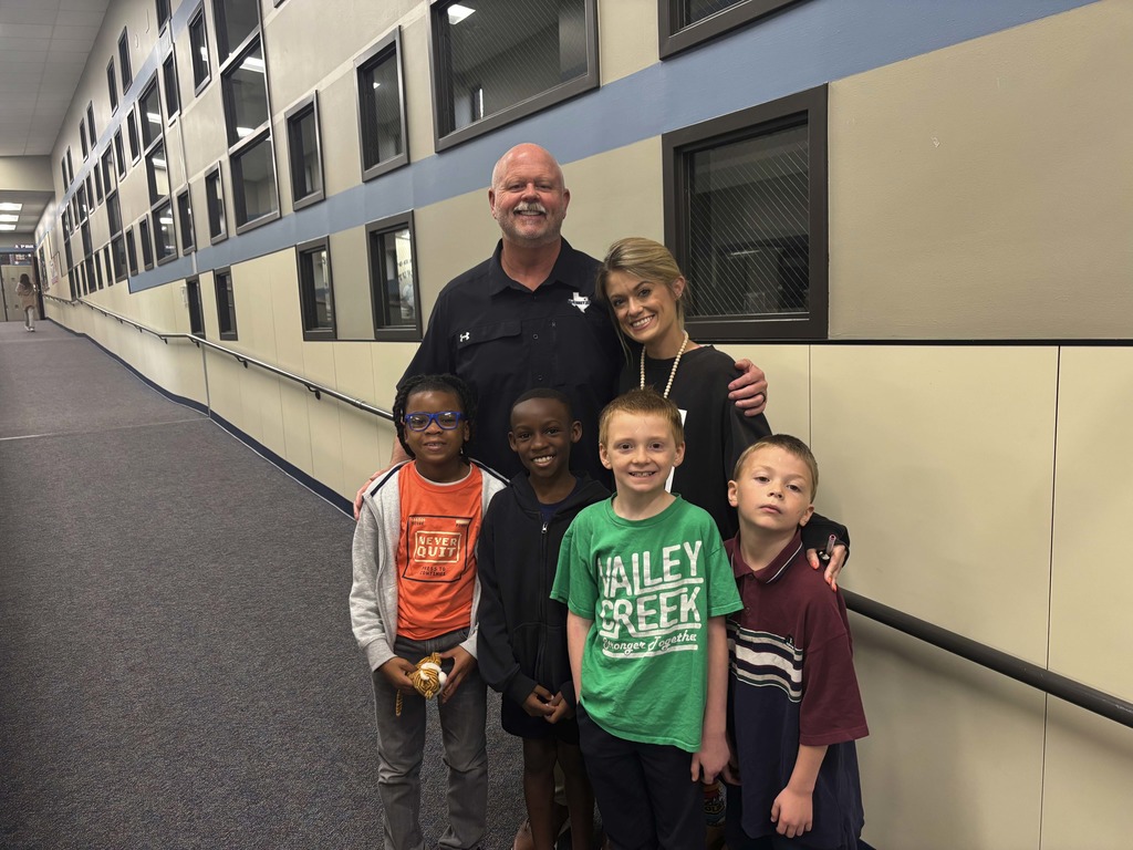 shawn pratt takes a photo with a teacher and students and valley creek elementary 