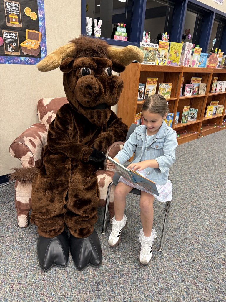 A student reading a story to Lucky the Longhorn!