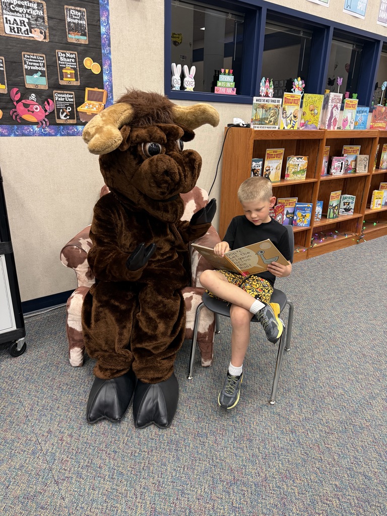 A student reading a story to Lucky the Longhorn!
