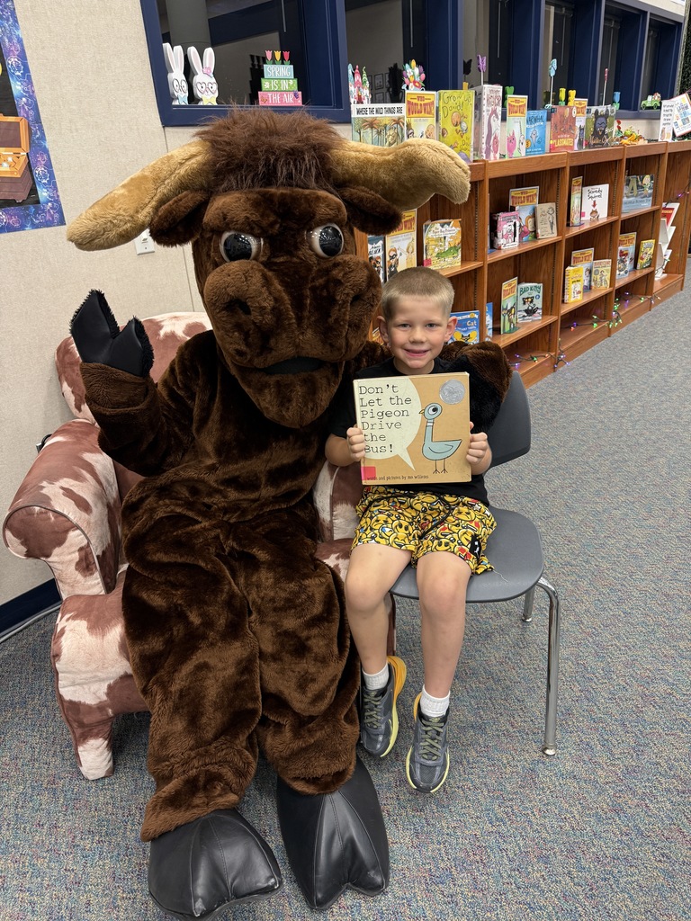A student reading a story to Lucky the Longhorn!