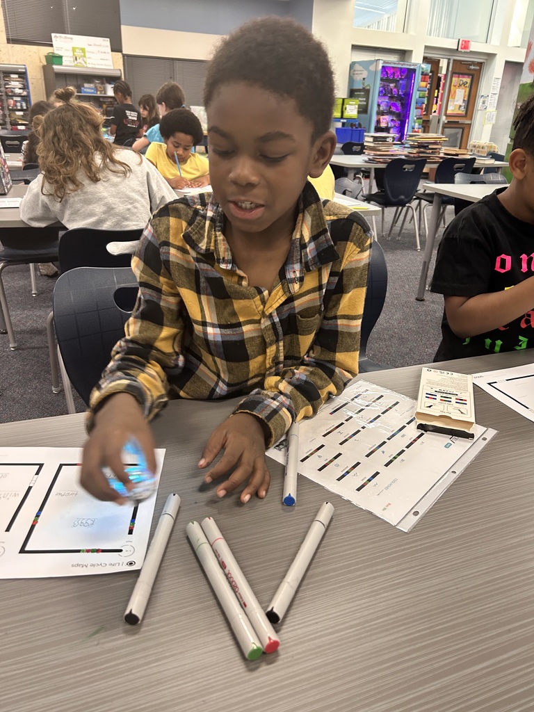 3rd graders applying what they learned about life cycles  while coding Ozobots.