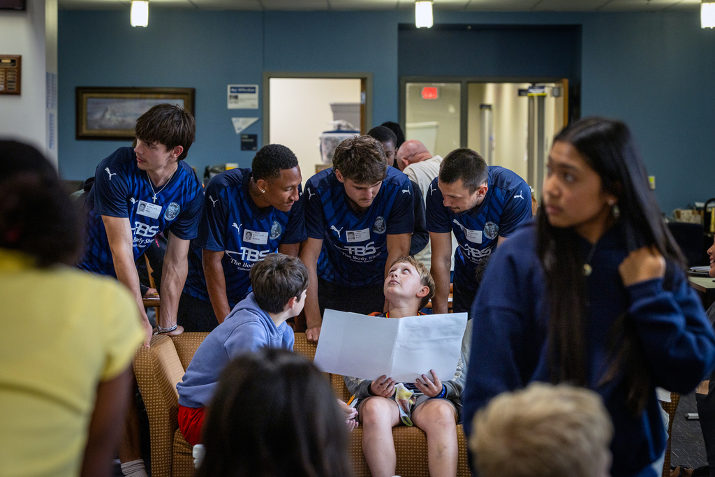 players talking with students about project