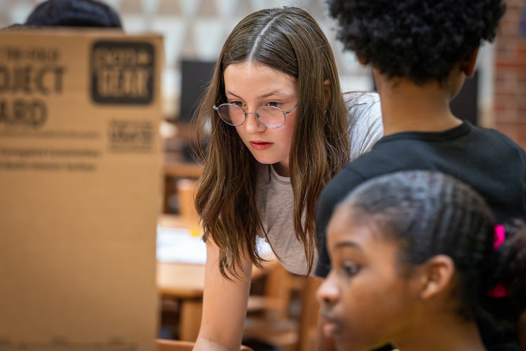 girl looking intently at project that she is working on