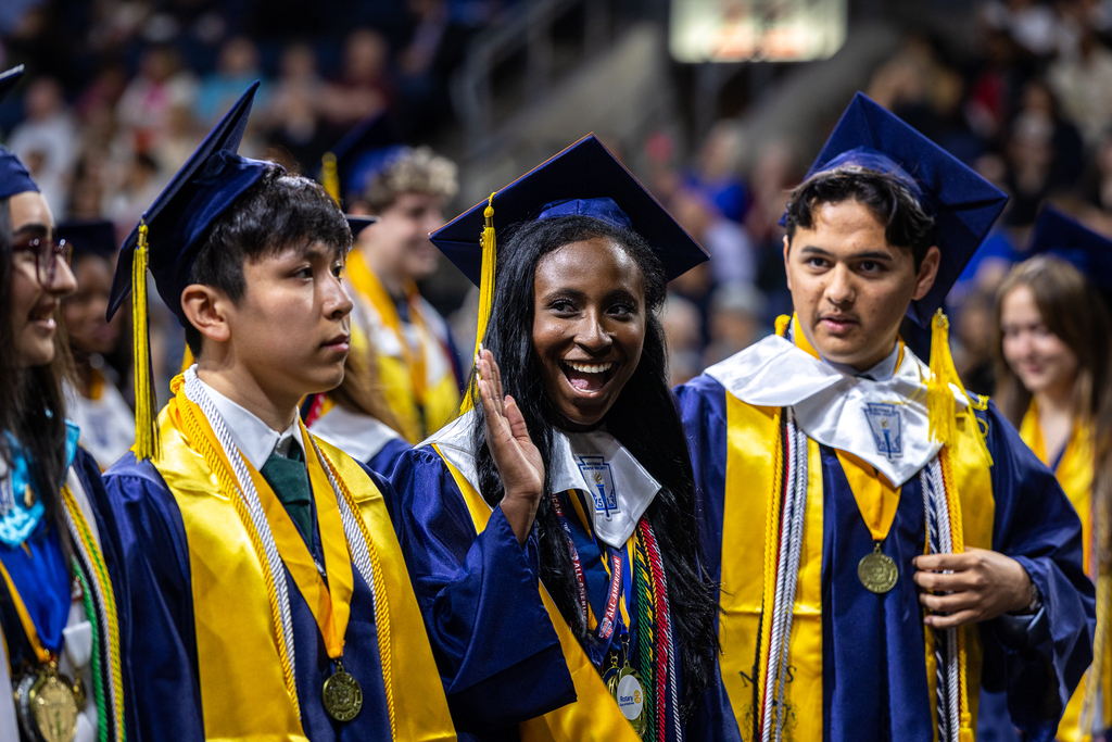 female graduate smiling and waving 