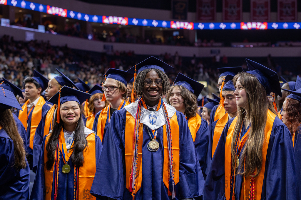 graduates in the front row standing and smiling