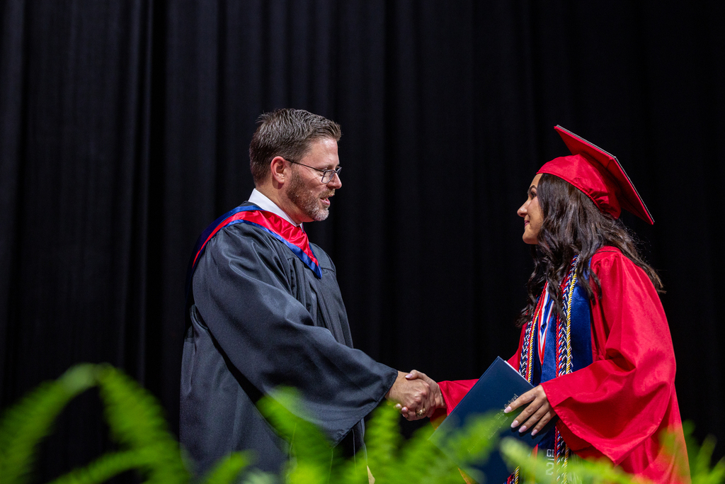 principal david hodum shaking the hand of a graduate