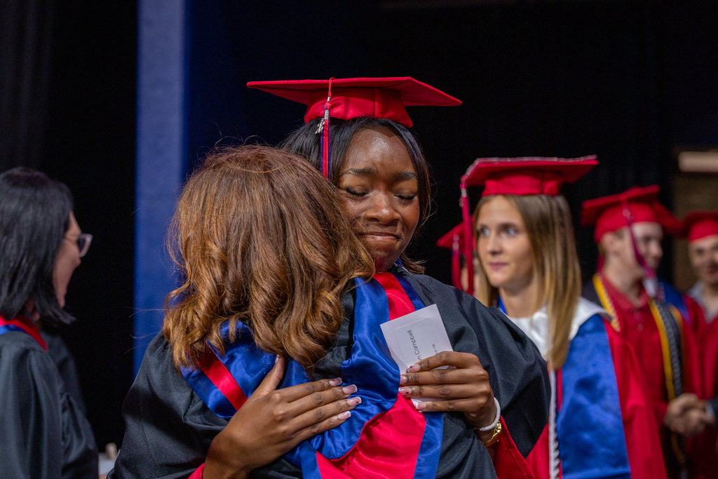 female graduate hugging a teacher