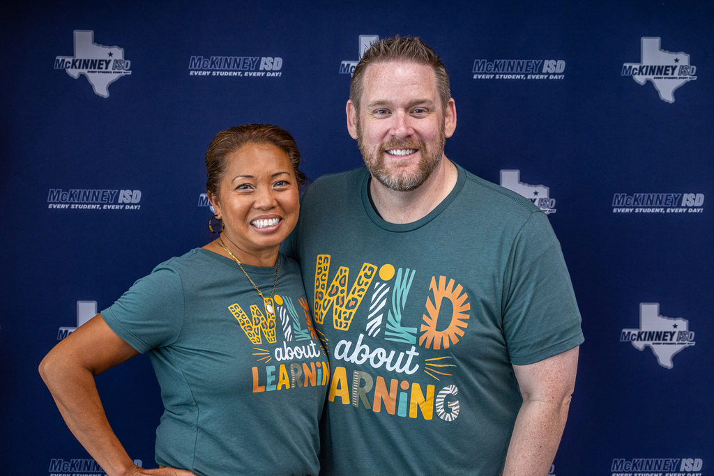 principal and ap smiling in front of backdrop