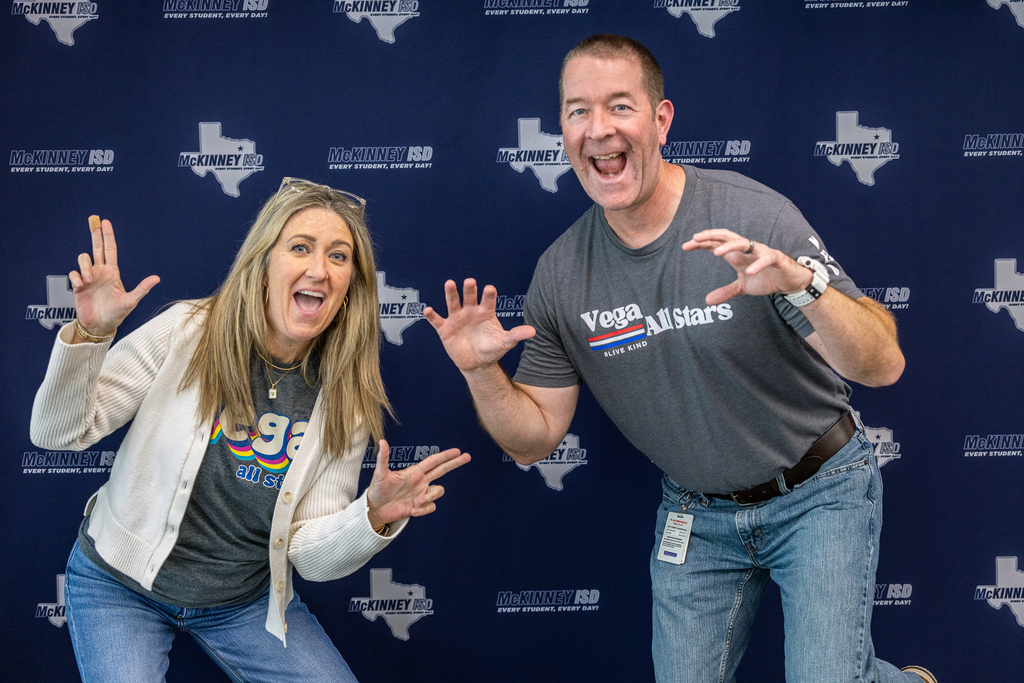 principal and ap doing fun pose in front of backdrop
