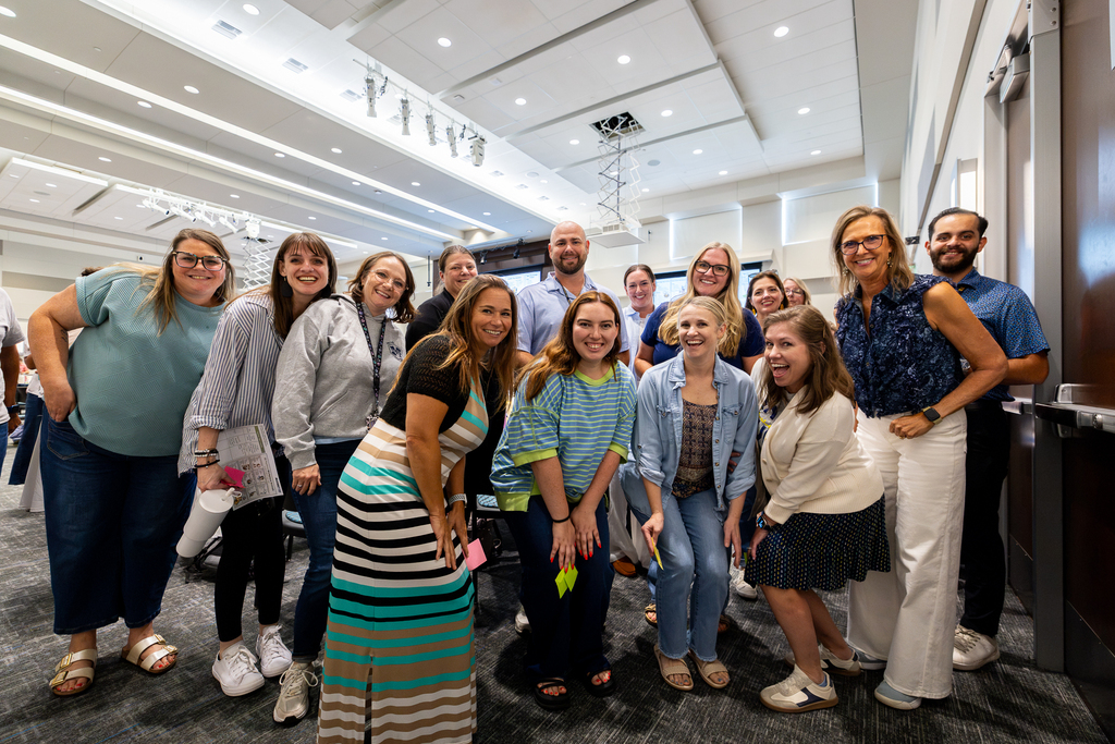group of teachers posing for camera and smiling