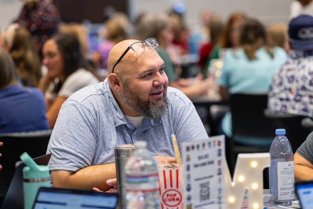 male teacher talking at table