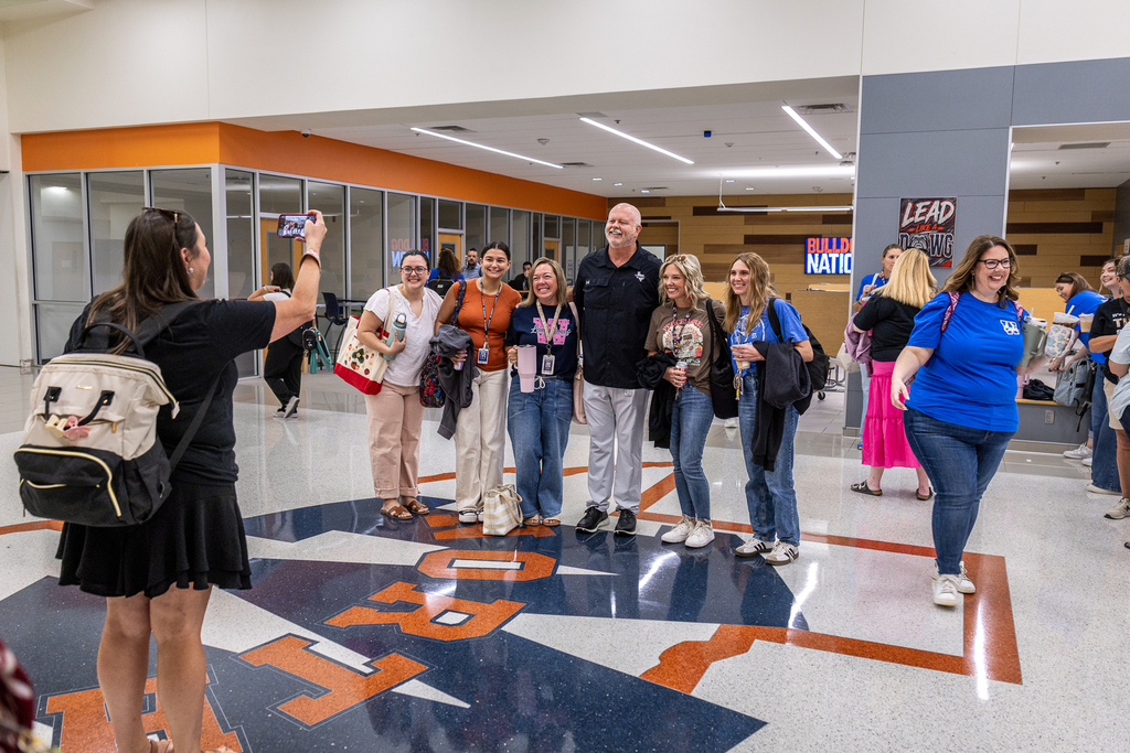 superintendent with a group of teachers smiling for photo